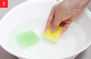 1ぬるま湯（約30℃）をはった洗面器に緑色と黄色のスポンジを浸す。空気の泡が出なくなるまでギュッと握ってたっぷり水を含ませる。